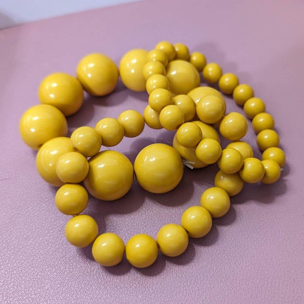 Yellow bracelets, on elastic cord